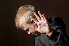 Boy with Stop Written on Hand