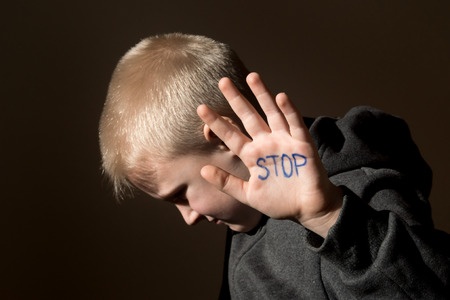 Boy with Stop Written on Hand