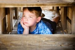 Boy in Blue Shirt Hiding and Looking Unhappy