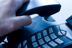 6024357 - Hand picking up an office phone.